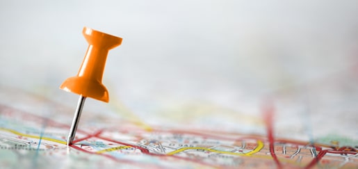 Orange push pin marking a spot on a map
